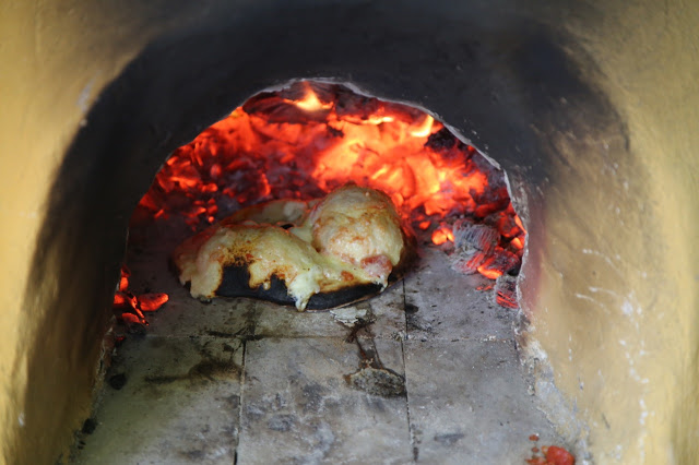 Making pizza in a wood fired cob oven, Norfolk